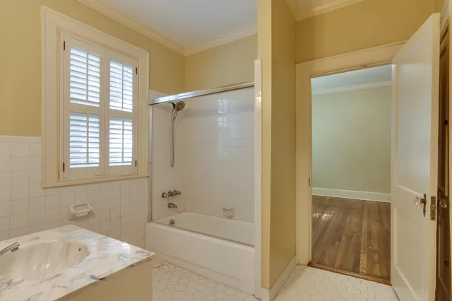 a bathroom with a tub shower and sink