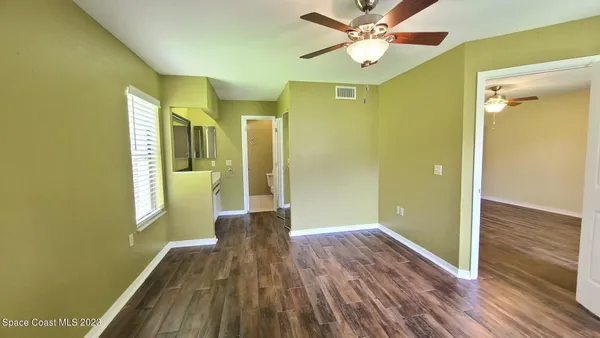 a view of hallway with livingroom and wooden floor