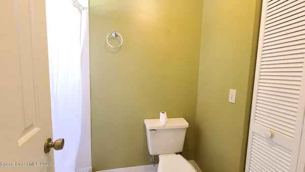 a white toilet sitting next to a shower