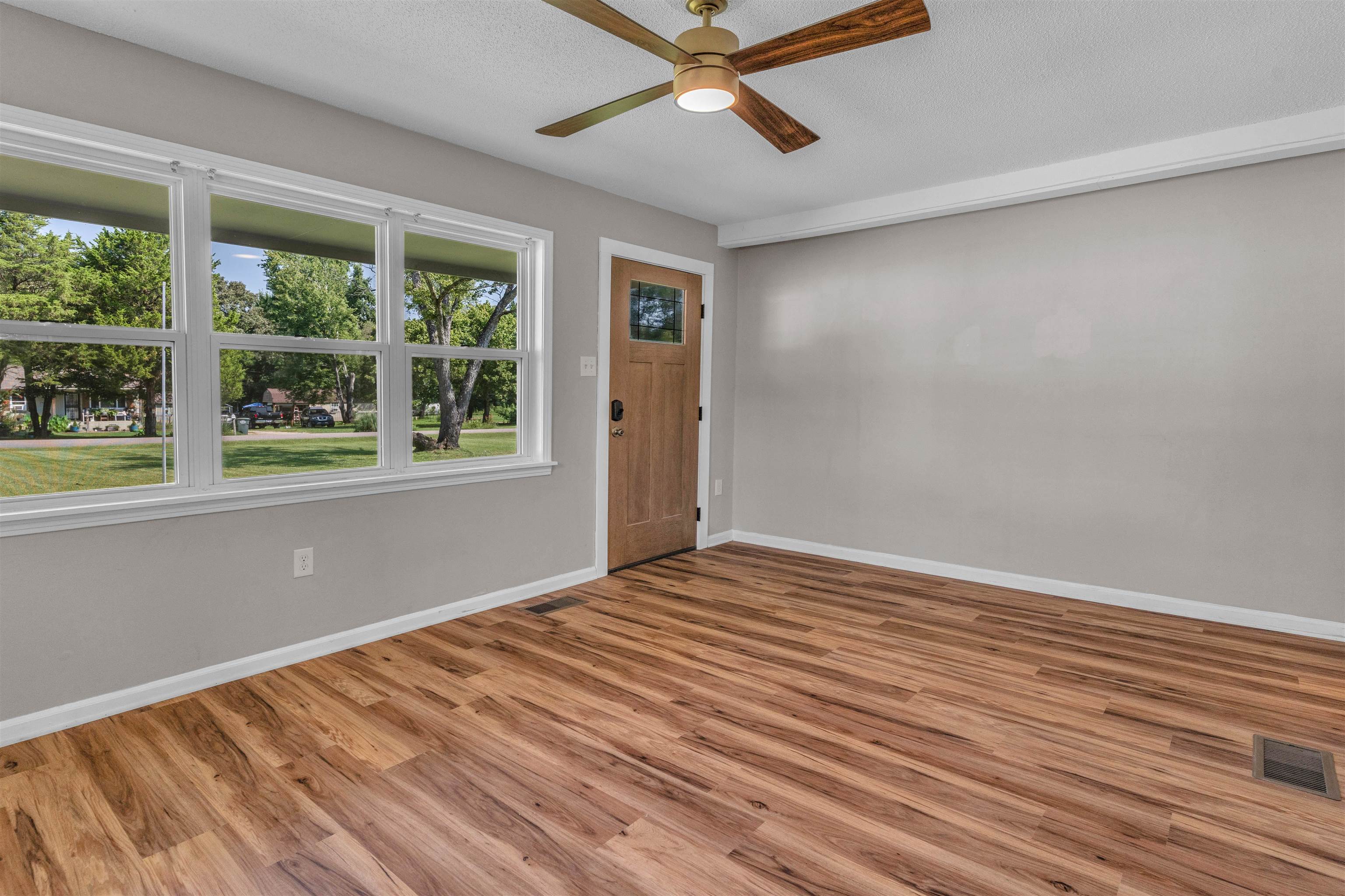 185 Henry Road Somerville, TN 38068 - Photo 5 of 21 Wood-finish flooring, light gray wall paint, and a multi-pane window create a bright interior