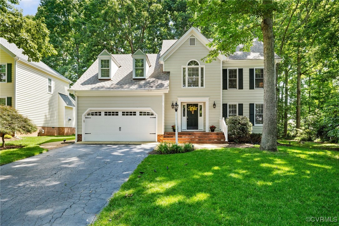 a front view of a house with a yard and garage