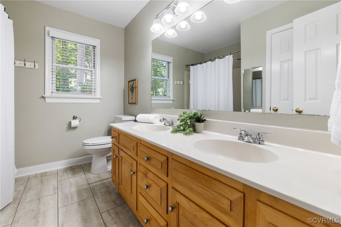 15210 Powell Grove Road Midlothian, VA 23112 - Photo 25 of 36 a spacious bathroom with a granite countertop sink a toilet and a mirror