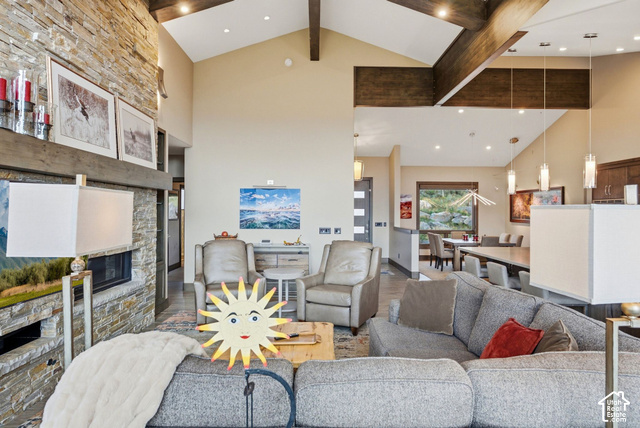 1130 Pace Road Park City, UT 84098 - Photo 15 of 73 Vaulted ceilings with exposed wood beams, a stone-clad fireplace with a dark wood mantel, recessed lighting, and a dining area with a window