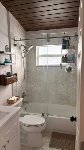 a bathroom with a bathtub shower sink vanity and toilet