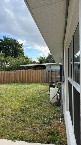 a view of a backyard with furniture and garden