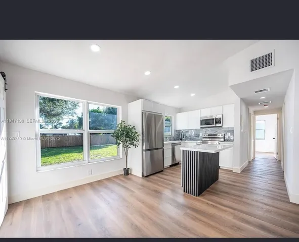 a open kitchen with a sink and dishwasher with a large window