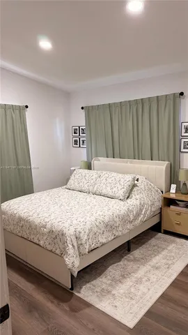 a bedroom with a large bed and a wooden floor