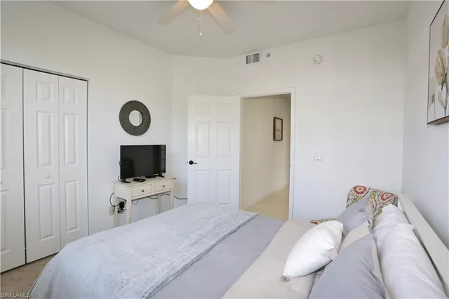 a bedroom with a bed and a flat tv screen on the dresser