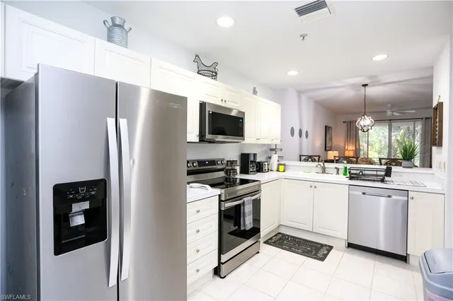 a kitchen with a sink stainless steel appliances and white cabinets