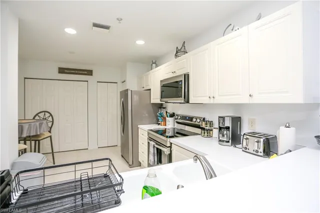 a kitchen with stainless steel appliances kitchen island granite countertop a stove a sink a refrigerator and a microwave