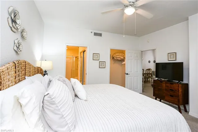a bedroom with a bed and a flat tv screen on dresser