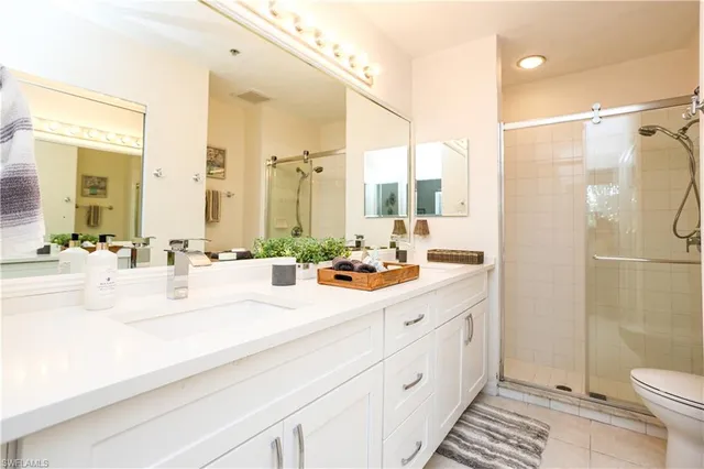 a bathroom with a double vanity sink toilet and shower
