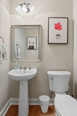 a bathroom with a toilet sink and mirror
