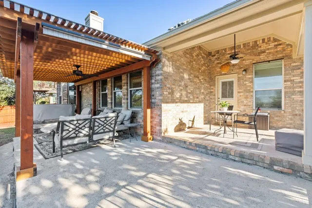 a view of a patio with table and chairs with wooden floor and fence