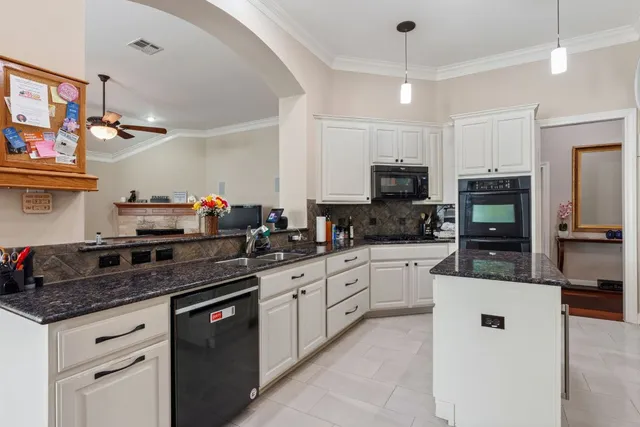 a kitchen with stainless steel appliances granite countertop a sink a stove top oven a counter space and cabinets