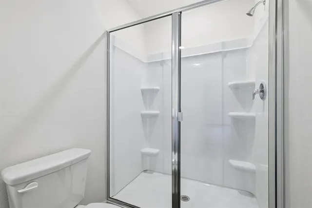 a bathroom with a double vanity sink toilet and shower
