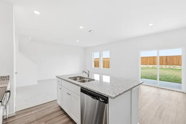 a kitchen with stainless steel appliances a refrigerator and a stove top oven