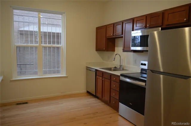 a kitchen with stainless steel appliances granite countertop a refrigerator stove and sink