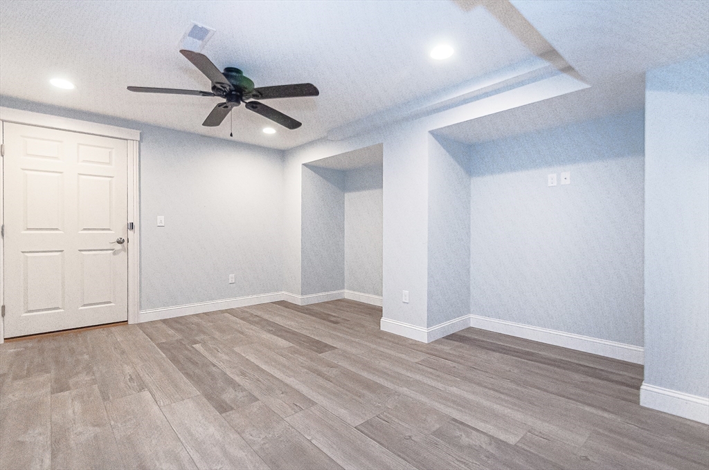 501 Point Road Marion, MA 02738 - Photo 32 of 42 an empty room with wooden floor ceiling fan and windows