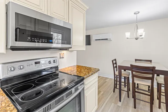 a kitchen with a stove a microwave and a dining table