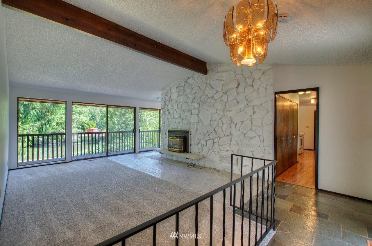 22004 Southeast Bain Road Renton, WA 98058 - Photo 4 of 27 a view of an empty room with a fireplace and a chandelier