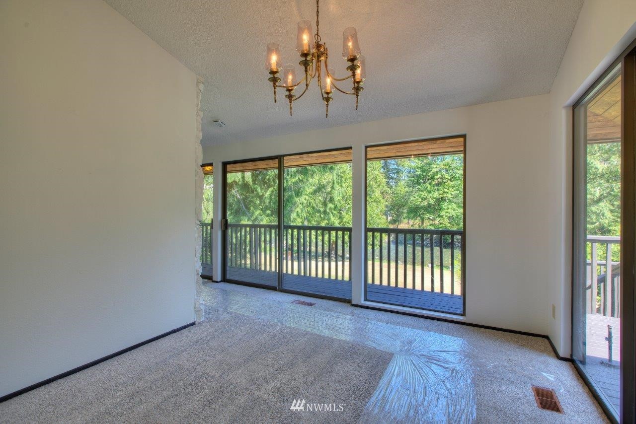 22004 Southeast Bain Road Renton, WA 98058 - Photo 6 of 27 a view of a big room with wooden floor chandelier and windows