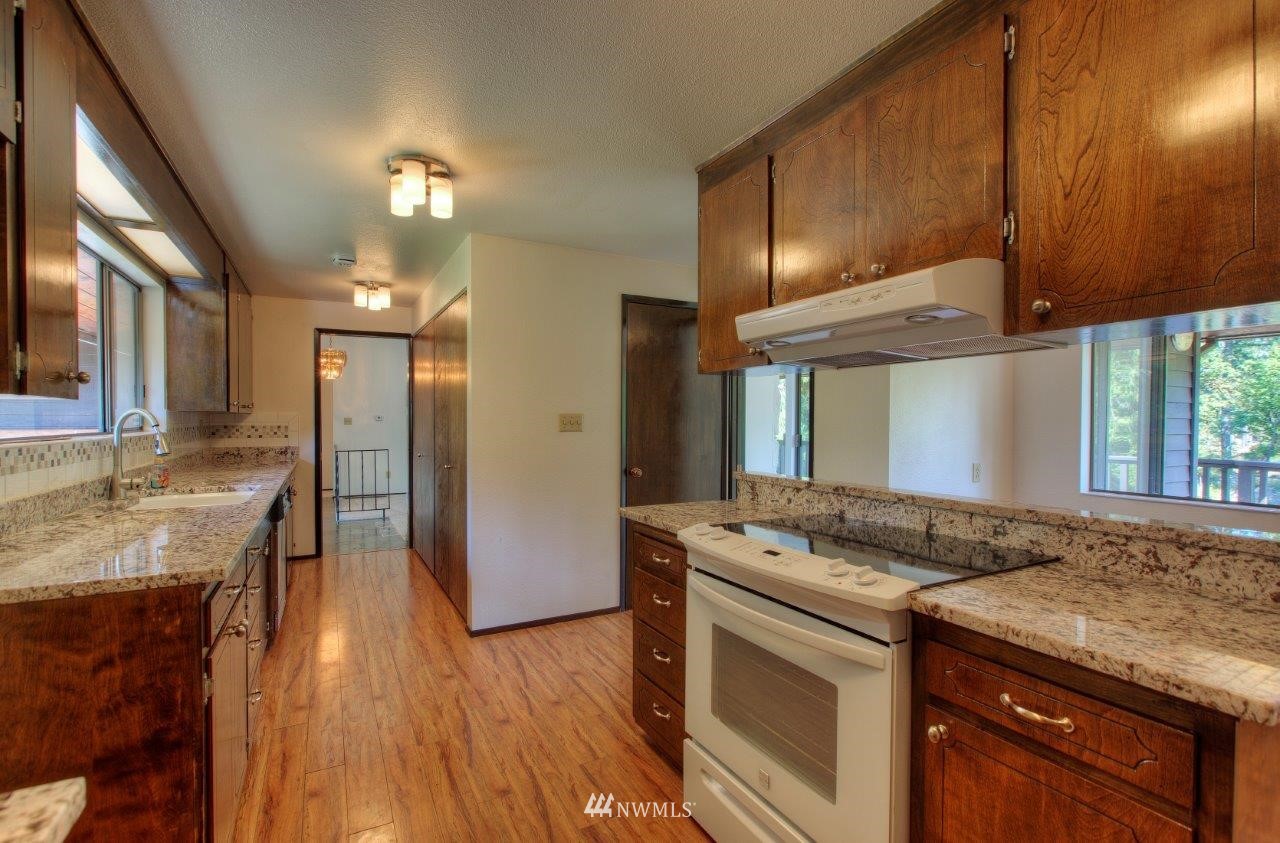 22004 Southeast Bain Road Renton, WA 98058 - Photo 8 of 27 a kitchen with stainless steel appliances granite countertop wooden cabinets and a granite counter tops