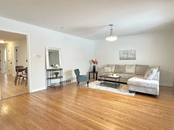 a living room with furniture and a wooden floor