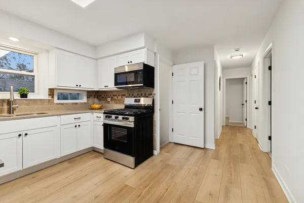 a kitchen with stainless steel appliances a refrigerator sink and microwave