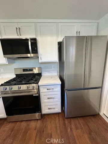 a kitchen with stainless steel appliances white cabinets and a stove top oven