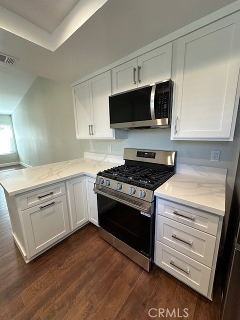44649 La Paz Road, Unit F Temecula, CA 92592 - Photo 10 of 23 a kitchen with stainless steel appliances white cabinets and a stove top oven