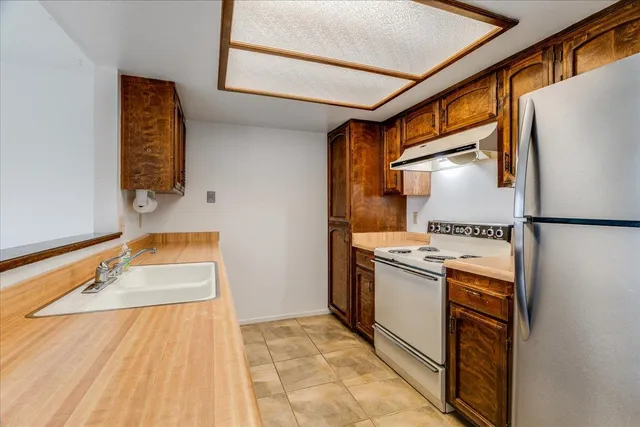a kitchen with stainless steel appliances granite countertop a sink stove and refrigerator