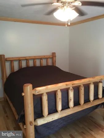 a bed sitting in a bedroom next to a window with wooden floor