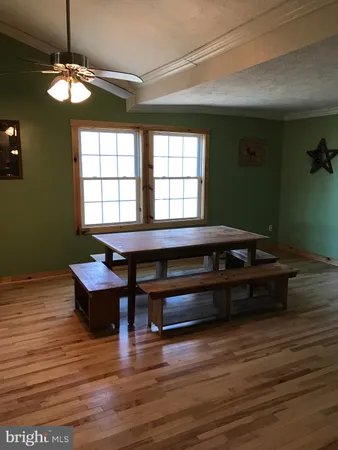 a living room with a table chairs and a window