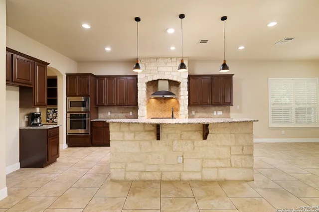 a large kitchen with kitchen island a counter top stainless steel appliances and cabinets