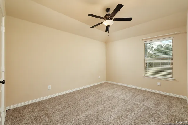 an empty room with a window and a fan