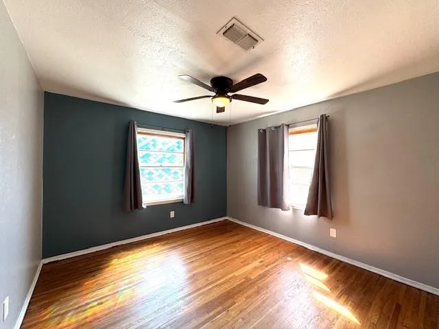 a view of an empty room and window and chandelier fan