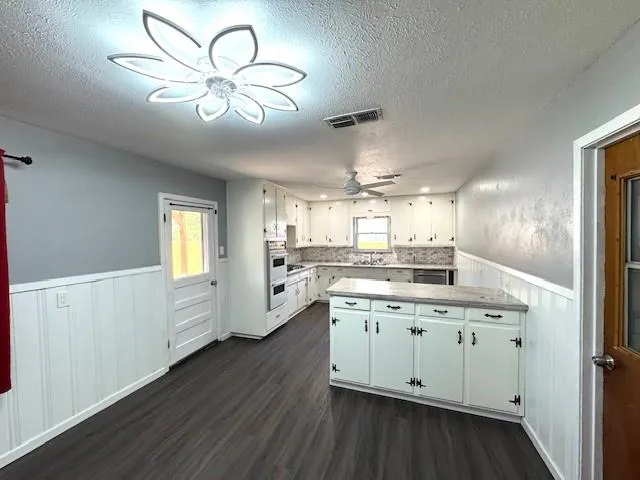 a large white kitchen with a window