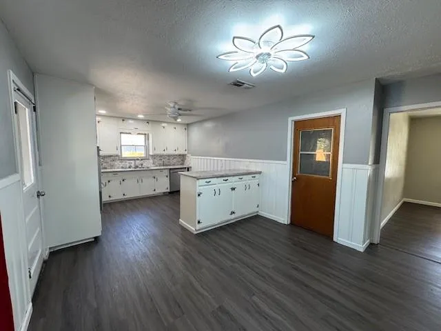a view of a kitchen with a sink dishwasher a refrigerator and wooden floor