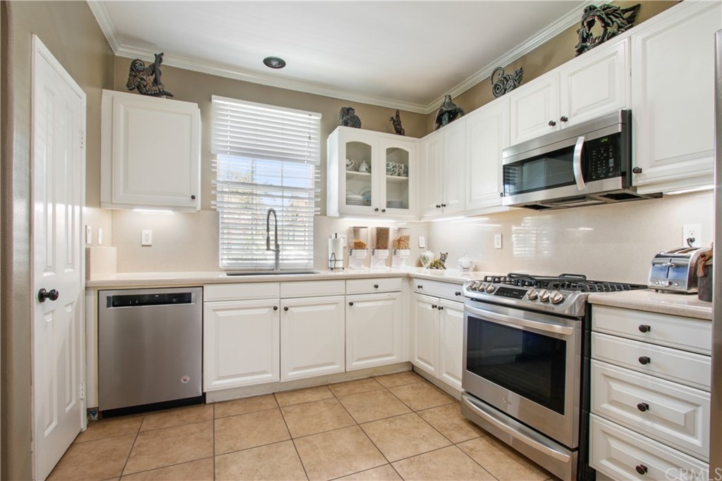 10 Alevera Irvine, CA 92618 - Photo 5 of 22 a kitchen with stainless steel appliances granite countertop white cabinets a sink and a stove