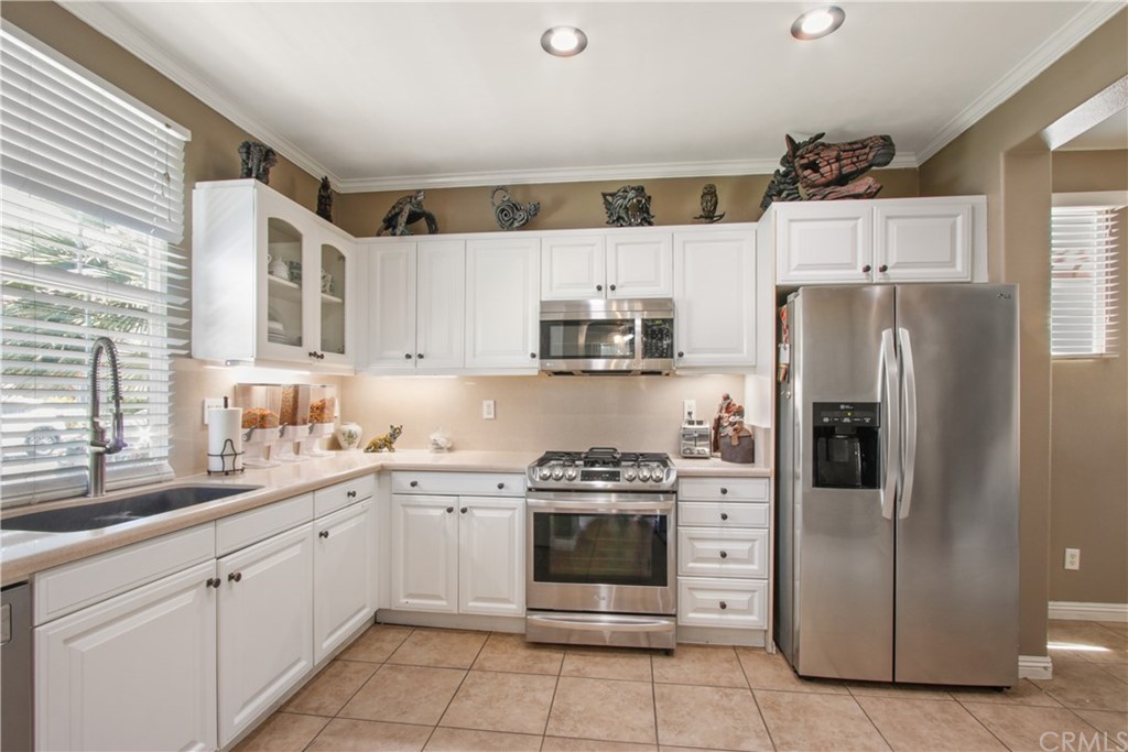 10 Alevera Irvine, CA 92618 - Photo 7 of 22 a kitchen with stainless steel appliances a refrigerator sink and cabinets