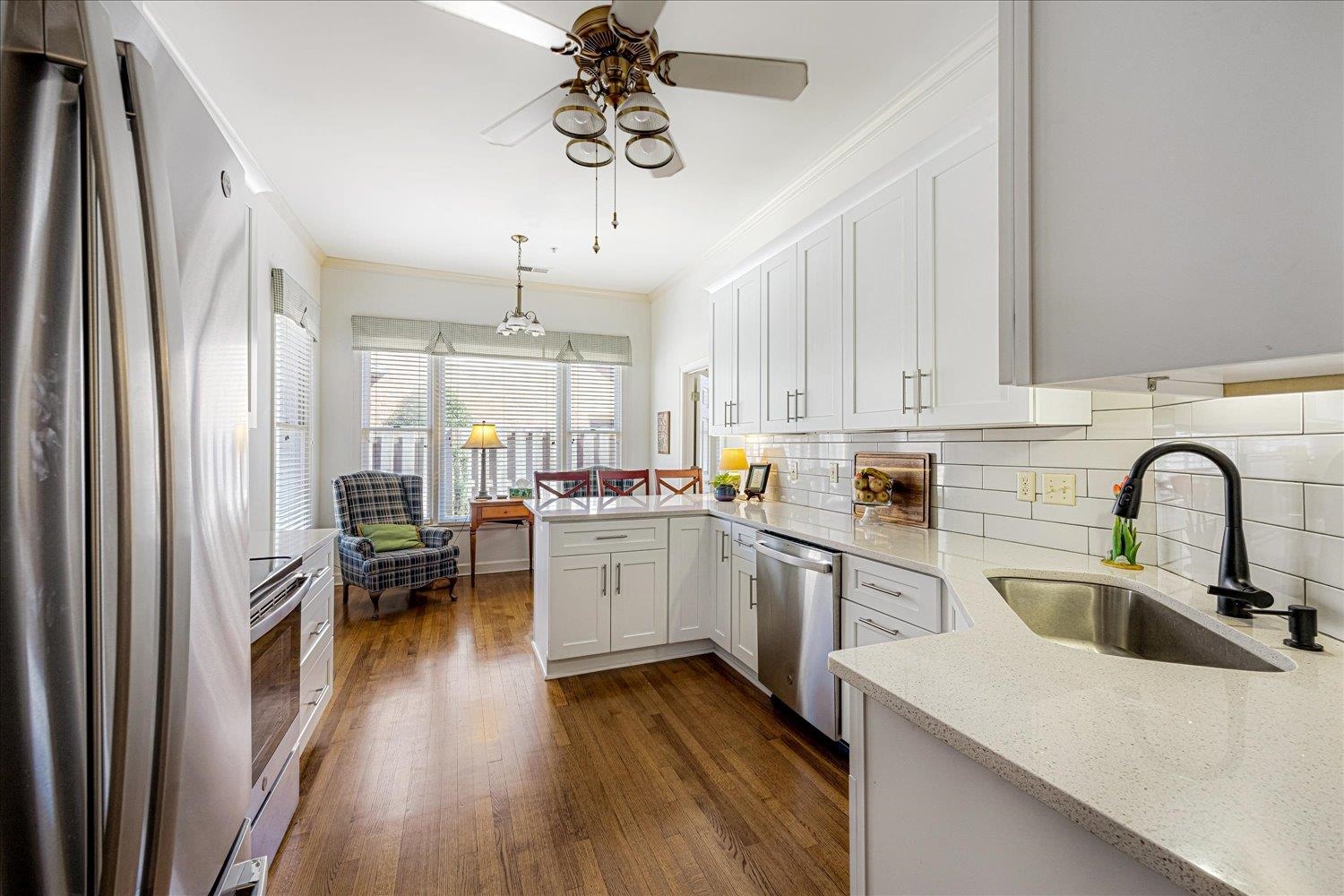 1727 Village Ridge Road Collierville, TN 38017 - Photo 16 of 33 a kitchen with a sink dishwasher a stove and white cabinets with wooden floor
