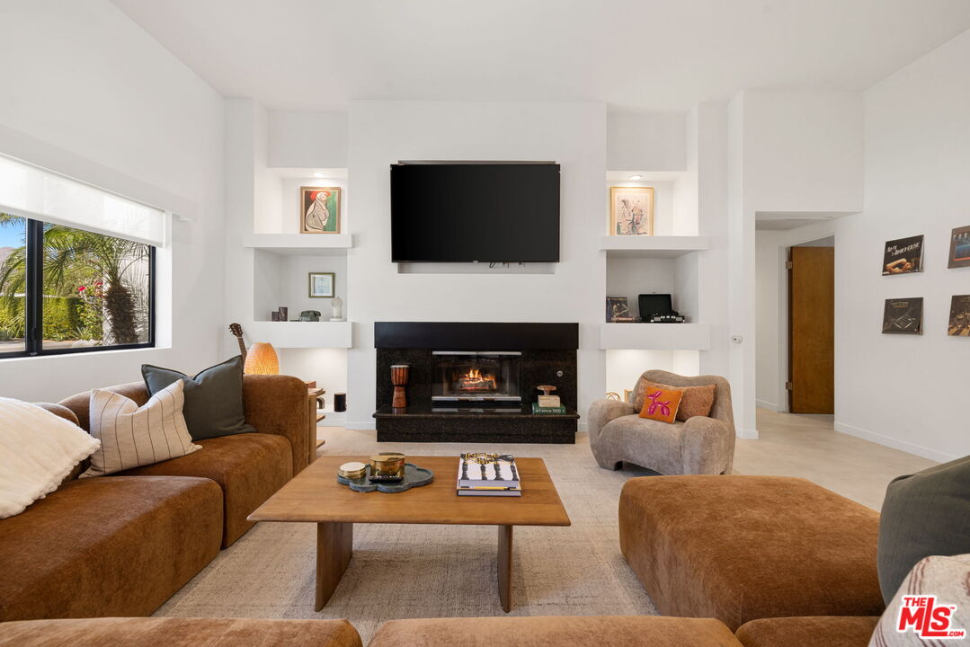 1414 Sagebrush Road Palm Springs, CA 92264 - Photo 15 of 48 a living room with furniture a flat screen tv and a fireplace
