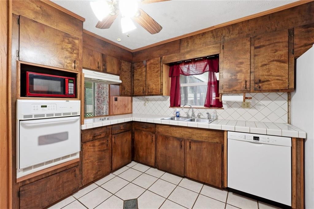 399 Donahoo Road Southeast Silver Creek, GA 30173 - Photo 7 of 22 a kitchen with stainless steel appliances granite countertop a sink and dishwasher a stove with wooden cabinets
