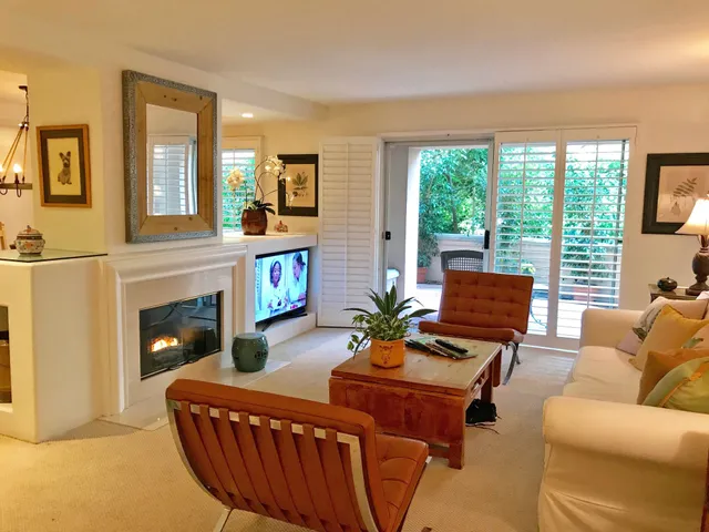a living room with furniture a fireplace and a large window