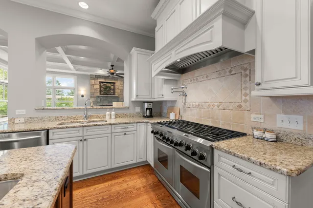 a kitchen with granite countertop a refrigerator and a wooden floor