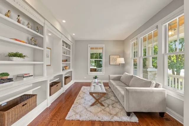 a living room with furniture a fireplace a flat screen tv and a large window