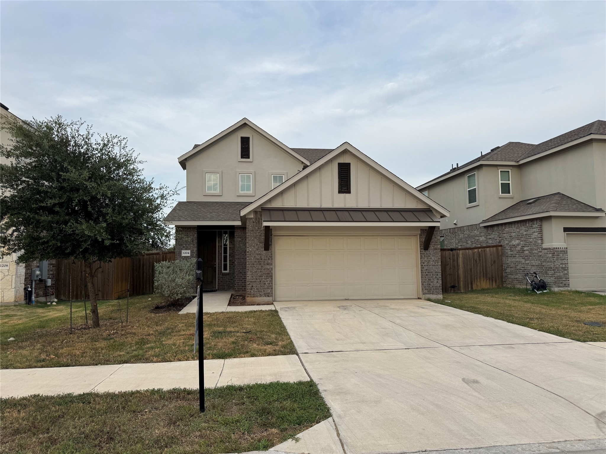 1204 Morning View Road Georgetown, TX 78628 - Photo 1 of 1 View of front of home featuring driveway, board and batten siding, an attached garage, and brick siding