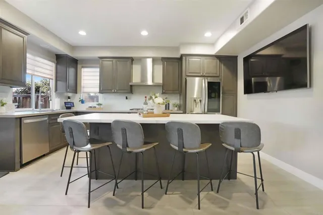 a kitchen with a dining table chairs cabinets and stainless steel appliances
