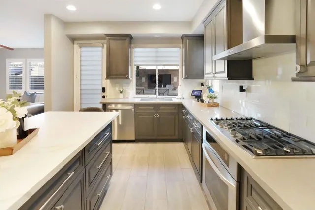 a kitchen with a refrigerator a stove and a sink with wooden floor